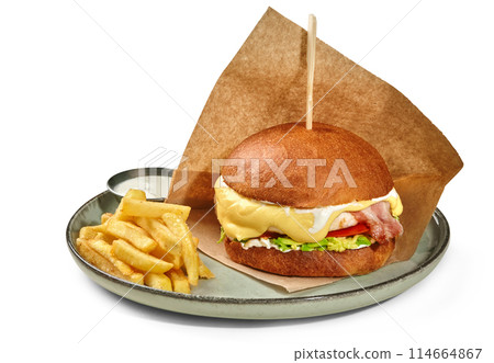 Chicken burger with bacon and avocado served with fries 114664867