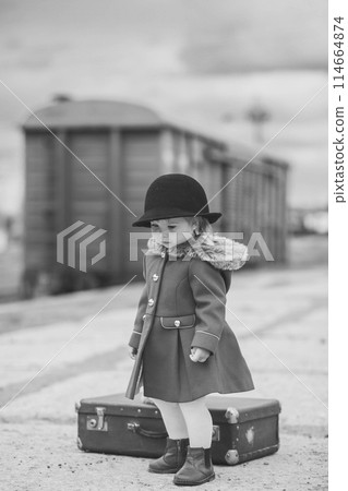 Retro photo of a baby girl who is waiting for a train Retro photo of a baby girl who is waiting for a train 114664874