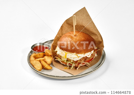 Hamburger with beef patty and fried egg served with baked potatoes 114664878