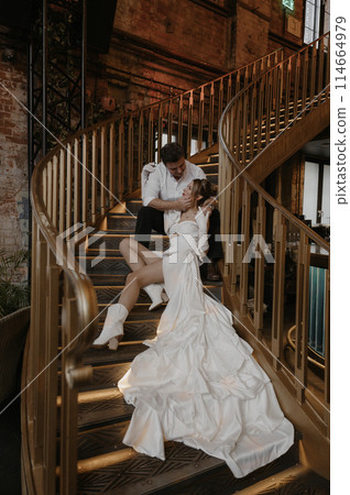 A young couple in wedding looks posing in a stylish loft bar. 114664979