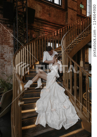 A young couple in wedding looks posing in a stylish loft bar. 114664980