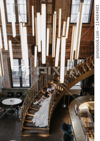 A young couple in wedding looks posing in a stylish loft bar. 114664983