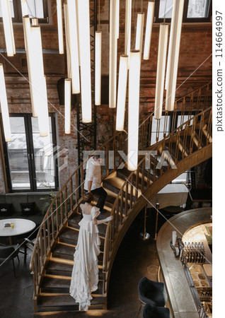 A young couple in wedding looks posing in a stylish loft bar. 114664997