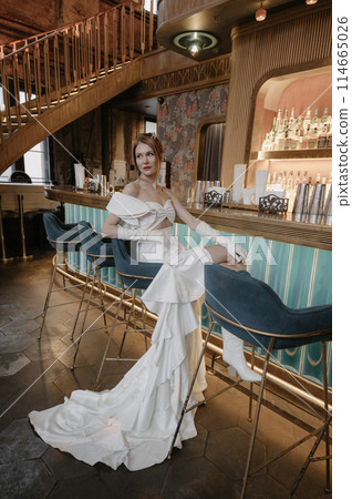A young couple in wedding looks posing in a stylish loft bar. A young couple in wedding looks posing in a stylish loft bar. 114665026