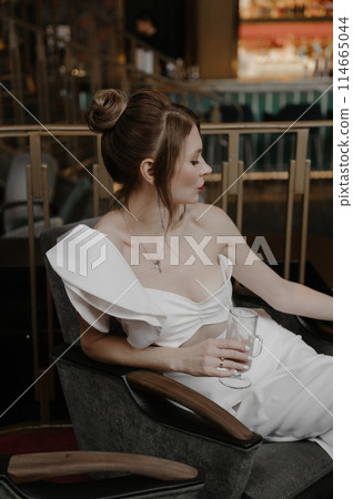 A young couple in wedding looks posing in a stylish loft bar. A young couple in wedding looks posing in a stylish loft bar. 114665044
