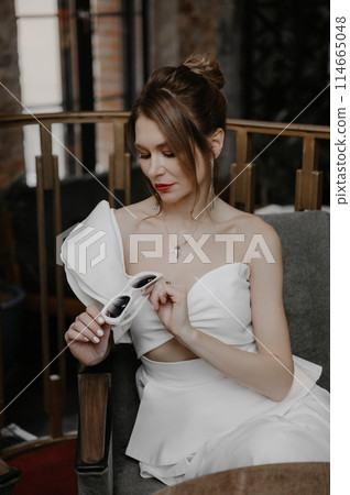 A young couple in wedding looks posing in a stylish loft bar. A young couple in wedding looks posing in a stylish loft bar. 114665048