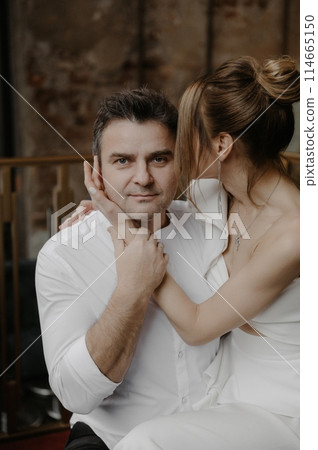 A young couple in wedding looks posing in a stylish loft bar. 114665150