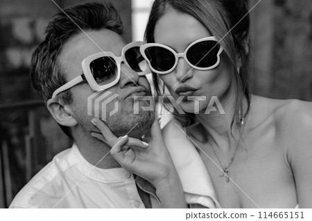 A young couple in wedding looks posing in a stylish loft bar. A young couple in wedding looks posing in a stylish loft bar. 114665151