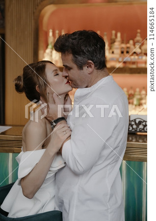 A young couple in wedding looks posing in a stylish loft bar. A young couple in wedding looks posing in a stylish loft bar. 114665184