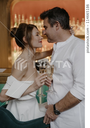 A young couple in wedding looks posing in a stylish loft bar. A young couple in wedding looks posing in a stylish loft bar. 114665186