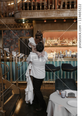 A young couple in wedding looks posing in a stylish loft bar. 114665222