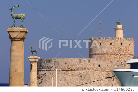Old stone lighthouse illuminated by the sun at Fort St. Nicholas in Rhodes. 114666253
