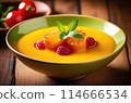 Indulge in the elegance of this creamy soup adorned with caramelized onions and fresh raspberries 114666534