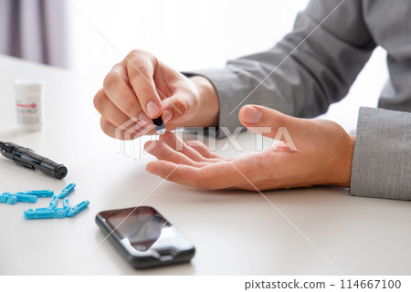Close-up of man hands measuring glucose level 114667100