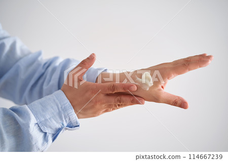 Hands in a blue shirt smear cream. Hands in a blue shirt smear cream. 114667239