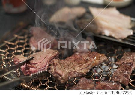 Korean Style Barbecue on stainless grill. BBQ rare meat with soft focus Korean Style Barbecue on stainless grill. BBQ rare meat with soft focus 114667295