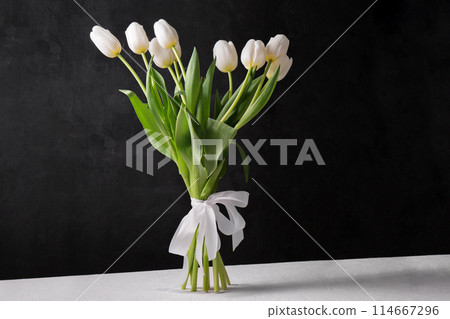 A bouquet of white tulips on a black background 114667296