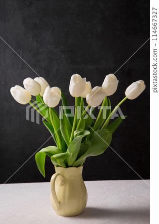 A bouquet of white tulips in a yellow jug A bouquet of white tulips in a yellow jug 114667327