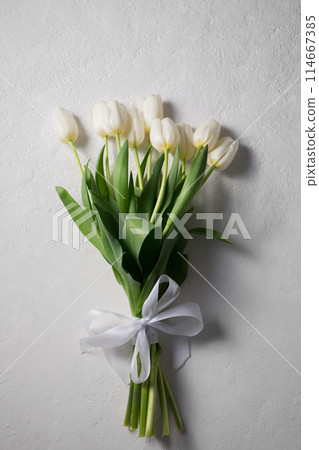 A bouquet of white tulips on a light background 114667385