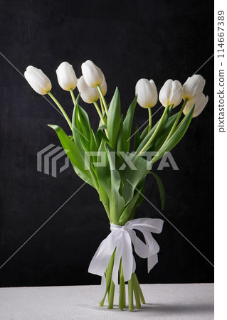 A bouquet of white tulips on a black background A bouquet of white tulips on a black background 114667389
