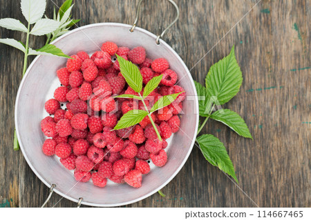 Ripe raspberries in a vintage sieve Ripe raspberries in a vintage sieve 114667465