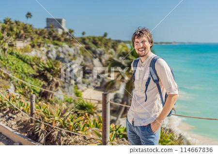 Man tourist enjoying the view Pre-Columbian Mayan walled city of Tulum, Quintana Roo, Mexico, North America, Tulum, Mexico. El Castillo - castle the Mayan city of Tulum main temple 114667836
