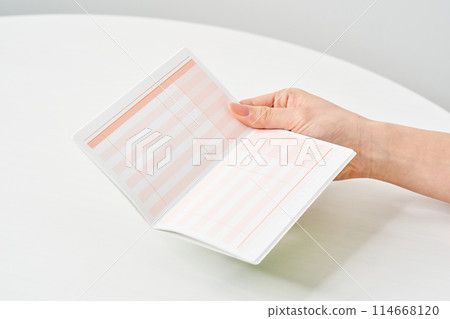 A woman's hand looking at her bank passbook 114668120