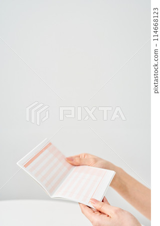 A woman's hand looking at her bank passbook 114668123