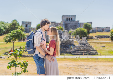 Couple man and woman tourists enjoying the view Pre-Columbian Mayan walled city of Tulum, Quintana Roo, Mexico, North America, Tulum, Mexico. El Castillo - castle the Mayan city of Tulum main temple Couple man and woman tourists enjoying the view Pre-Columbian Mayan walled city of Tulum, Quintana Roo, Mexico, North America, Tulum, Mexico. El Castillo - castle the Mayan city of Tulum main temple 114668321