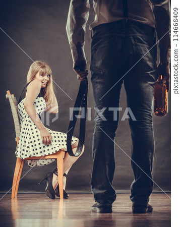 Man alcoholic beating his scared woman with belt 114668409