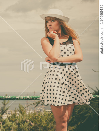 Beautiful retro style girl in polka dotted dress. 114668422