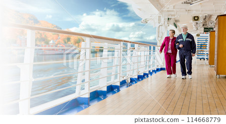 Banner of a Happy Senior Adult Couple Strolling Along the Cruise Ship Deck Exercising On a Crisp Fall Morning. Banner of a Happy Senior Adult Couple Strolling Along the Cruise Ship Deck Exercising On a Crisp Fall Morning. 114668779