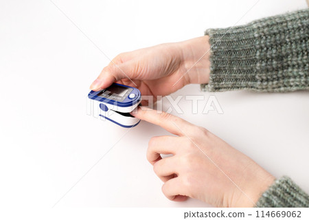 Woman using fingertip pulse oximeter on white background, close up Woman using fingertip pulse oximeter on white background, close up 114669062