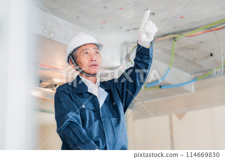 一位工匠在建築工地指指點點和檢查 一位工匠在建築工地指指點點和檢查 114669830