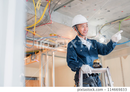 A craftsman checking something at a construction site A craftsman checking something at a construction site 114669833