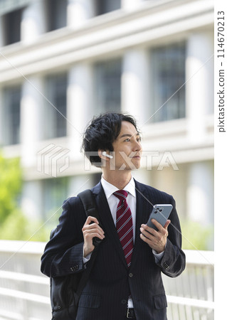 A businessman in his 30s holding a smartphone 114670213