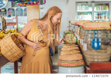 A pregnant woman is at a fruit stand in a grocery store Pregnant woman buying organic vegetables and fruits at Mexican style farmers market A pregnant woman is at a fruit stand in a grocery store Pregnant woman buying organic vegetables and fruits at Mexican style farmers market 114671070