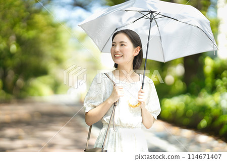 A young woman holding a parasol 114671407