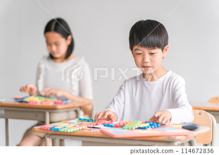 在學校教室裡使用字母玩具學習英語的小學生（低年級） 114672836