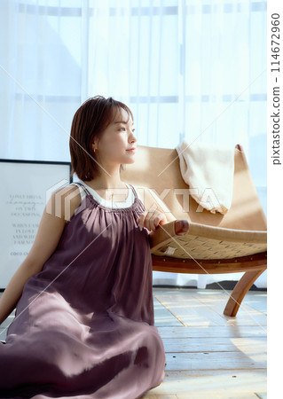 A woman relaxing in a chair in a room 114672960