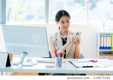 Business woman using a smartphone in the office 114673292