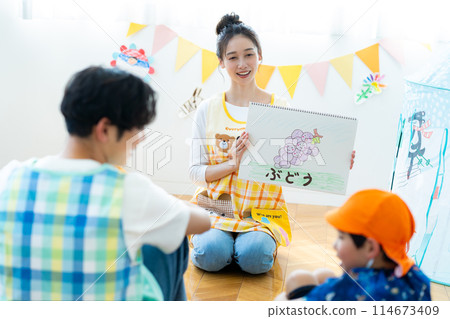 A nursery teacher reading aloud A nursery teacher reading aloud 114673409
