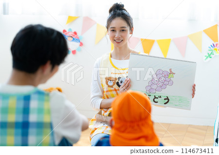 A nursery teacher reading aloud 114673411