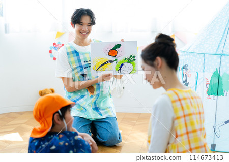 A nursery teacher reading aloud A nursery teacher reading aloud 114673413
