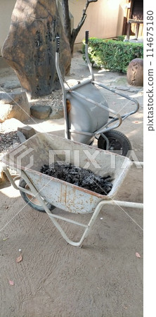 Wheelbarrow carrying ashes 114675180