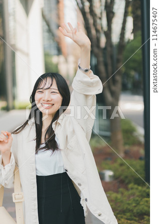 年輕女子在街上揮手 114675407