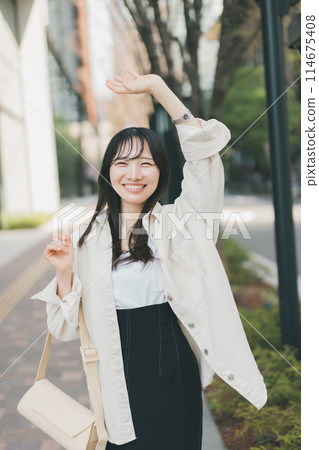 Young woman waving in the street Young woman waving in the street 114675408