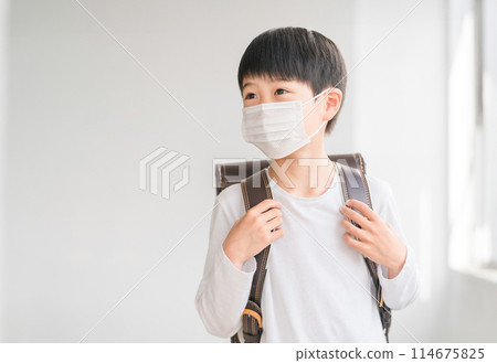 Elementary school boy wearing a mask at school Elementary school boy wearing a mask at school 114675825