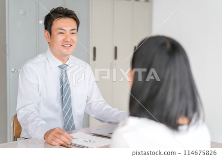 Male teacher, lecturer, teacher and female student having individual interview at school, cram school, preparatory school 114675826