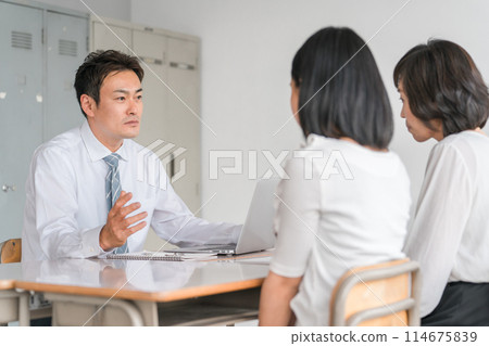 A male teacher giving a stern talk during a three-way conference with a dejected student and his/her guardian A male teacher giving a stern talk during a three-way conference with a dejected student and his/her guardian 114675839